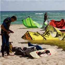 Équipement de surf et de kite aligné sur le sable